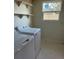 Functional laundry room with modern washer and dryer, plus handy shelving for efficient storage solutions at 128 Orange Ave, Edgewater, FL 32132