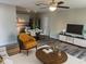 Open-concept living room with modern furnishings, ceiling fan, and adjacent kitchen with dining area at 128 Orange Ave, Edgewater, FL 32132