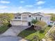 Stunning exterior view of home featuring a three-car garage, lush landscaping, and timeless architectural design at 13 Arena Blanca, Ponce Inlet, FL 32127