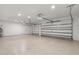Spacious three-car garage with ample lighting, epoxy flooring, and plenty of room for vehicles and storage at 13 Arena Blanca, Ponce Inlet, FL 32127