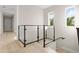 Upstairs hallway features glass railing and natural light through windows at 13 Arena Blanca, Ponce Inlet, FL 32127