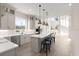 Bright, open-concept kitchen with modern appliances, island with seating, and hardwood floors at 13 Arena Blanca, Ponce Inlet, FL 32127