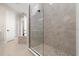 Elegant walk-in shower with pebble flooring, glass enclosure and marble-look tile surround at 13 Arena Blanca, Ponce Inlet, FL 32127