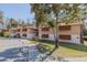 Condo building with parking lot and sidewalk, showcasing the exterior and surrounding greenery at 150 Wax Myrtle Woods Ct # 7B, Deltona, FL 32725