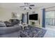 Living room with sliding glass doors to balcony, large television, and neutral paint at 150 Wax Myrtle Woods Ct # 7B, Deltona, FL 32725