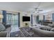 Spacious living room featuring large windows with blue curtains, a ceiling fan, and an adjacent dining area at 150 Wax Myrtle Woods Ct # 7B, Deltona, FL 32725