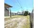 Backyard area featuring a mix of grass and sandy patches and a chain link fence in the background at 1816 Fern Palm Dr, Edgewater, FL 32132