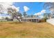 Large backyard with lush grass, mature trees, and white fencing at 1935 Fern Palm Dr, Edgewater, FL 32141