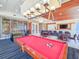Bright game room featuring a red billiard table, sleek lighting fixtures, and comfortable seating area at 231 Riverside Dr # 1509-1, Holly Hill, FL 32117