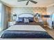 Serene main bedroom with patterned wallpaper, mirrored nightstands, and a ceiling fan at 231 Riverside Dr # 1509-1, Holly Hill, FL 32117