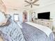Relaxing main bedroom featuring plush bedding, tv, and a light-filled hall to other rooms at 231 Riverside Dr # 1509-1, Holly Hill, FL 32117