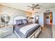 Comfortable main bedroom featuring decorative wallpaper, mirrored nightstands, and a ceiling fan at 231 Riverside Dr # 1509-1, Holly Hill, FL 32117