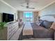 Well-lit main bedroom with balcony access, dresser with television, and decorative wallpaper at 231 Riverside Dr # 1509-1, Holly Hill, FL 32117