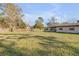 Large fenced backyard with ample green space, storage shed, and covered patio area at 2323 Queen Palm Dr, Edgewater, FL 32141