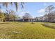 Spacious, fenced backyard with a covered patio, perfect for outdoor entertaining and relaxing at 2323 Queen Palm Dr, Edgewater, FL 32141