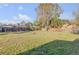 Expansive fenced backyard with lush grass and mature trees offers privacy at 2323 Queen Palm Dr, Edgewater, FL 32141