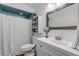 Bright bathroom with vanity, shower, and storage shelves at 2323 Queen Palm Dr, Edgewater, FL 32141