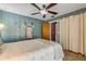 Comfortable bedroom with ceiling fan, wooden accent walls and quaint decor at 2323 Queen Palm Dr, Edgewater, FL 32141