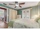 Bright bedroom with ceiling fan, wooden accent walls and doors to the backyard at 2323 Queen Palm Dr, Edgewater, FL 32141