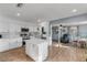 Open-concept kitchen with white cabinets, quartz countertops, stainless appliances, with dining area beyond at 2323 Queen Palm Dr, Edgewater, FL 32141