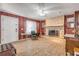 Cozy living room featuring a stone fireplace, wood-look floors, and natural lighting at 2323 Queen Palm Dr, Edgewater, FL 32141