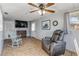 Cozy living room with wood floors, comfortable recliner, and ceiling fan at 2323 Queen Palm Dr, Edgewater, FL 32141