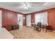 Cozy living room with red-painted walls, light wood-look floors, rocking chair, and vintage trunk at 2323 Queen Palm Dr, Edgewater, FL 32141
