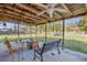 Inviting covered patio features bench seating, a fan, and backyard views at 2323 Queen Palm Dr, Edgewater, FL 32141