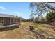 Large backyard featuring a screened-in patio and partial fencing at 234 Meadow Lake Dr, Edgewater, FL 32141