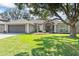 Charming one-story home featuring a manicured lawn, mature trees, and a two-car garage at 24 Coquina Point Dr, Ormond Beach, FL 32174