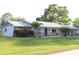 Single story home with brick and siding, metal roof, mature trees, and long driveway leading to a one car garage at 2404 Victory Palm Dr, Edgewater, FL 32141