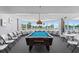 Bright game room with a pool table, chairs, tables, and ocean views from the bay windows at 2625 S Atlantic Ave # 11Nw, Daytona Beach, FL 32118