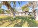 Wide backyard with mature trees and a spacious lawn at 3003 Tamarind Dr, Edgewater, FL 32141