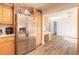 Bright kitchen featuring stainless steel refrigerator, light wood cabinetry, and wood-look flooring at 3003 Tamarind Dr, Edgewater, FL 32141