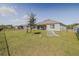 Spacious fenced backyard featuring a green lawn, young tree, and a charming patio set for outdoor living at 301 Sunset Point Dr, Ormond Beach, FL 32174