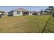 Spacious, fenced backyard with green grass, featuring a patio and swing set at 301 Sunset Point Dr, Ormond Beach, FL 32174
