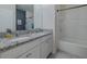 Modern bathroom featuring double sinks with granite countertops and tub shower at 301 Sunset Point Dr, Ormond Beach, FL 32174