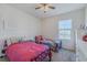 Bright bedroom features a ceiling fan and large window, furnished with two beds at 301 Sunset Point Dr, Ormond Beach, FL 32174