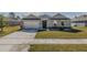 Exterior of a well-kept home with a two car garage, landscaping, and a driveway at 301 Sunset Point Dr, Ormond Beach, FL 32174