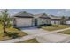 Inviting single-story home with a two-car garage, well-maintained lawn, and landscaped garden beds at 301 Sunset Point Dr, Ormond Beach, FL 32174