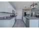 Well-lit kitchen with stainless steel appliances, white cabinetry, granite countertops, and gray tile flooring at 301 Sunset Point Dr, Ormond Beach, FL 32174