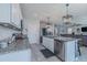 White kitchen featuring stainless steel appliances, granite counters, a center island, and an open layout at 301 Sunset Point Dr, Ormond Beach, FL 32174