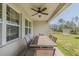 Covered outdoor patio area with a large wooden table and chairs, and a ceiling fan above at 301 Sunset Point Dr, Ormond Beach, FL 32174