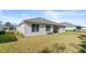 Expansive backyard featuring a well-maintained lawn, patio seating, and exterior lighting at 3029 Adrian Dr, Ormond Beach, FL 32174