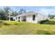 Spacious backyard with lush lawn, covered patio, and landscaped features at 3029 Adrian Dr, Ormond Beach, FL 32174