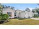 Inviting home featuring a well-manicured lawn, garden bed and a three car garage at 3029 Adrian Dr, Ormond Beach, FL 32174