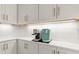 Close up of kitchen counter with coffee maker, white cabinets, and subway tile backsplash at 3029 Adrian Dr, Ormond Beach, FL 32174