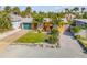 Aerial view of a well-maintained one-story home with a manicured lawn, mature trees, and a long driveway leading to the attached garage at 308 Normandy Ave, New Smyrna Beach, FL 32169
