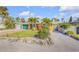 Charming one-story home with a well-maintained lawn, rock landscaping, and tall palm trees in the beautifully landscaped front yard at 308 Normandy Ave, New Smyrna Beach, FL 32169