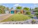 Charming home with a well-manicured front lawn, complemented by lush landscaping and vibrant tropical plants at 308 Normandy Ave, New Smyrna Beach, FL 32169